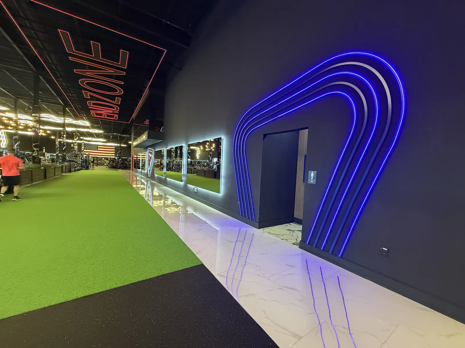 Blue neon arch opening onto the indoor turf lane